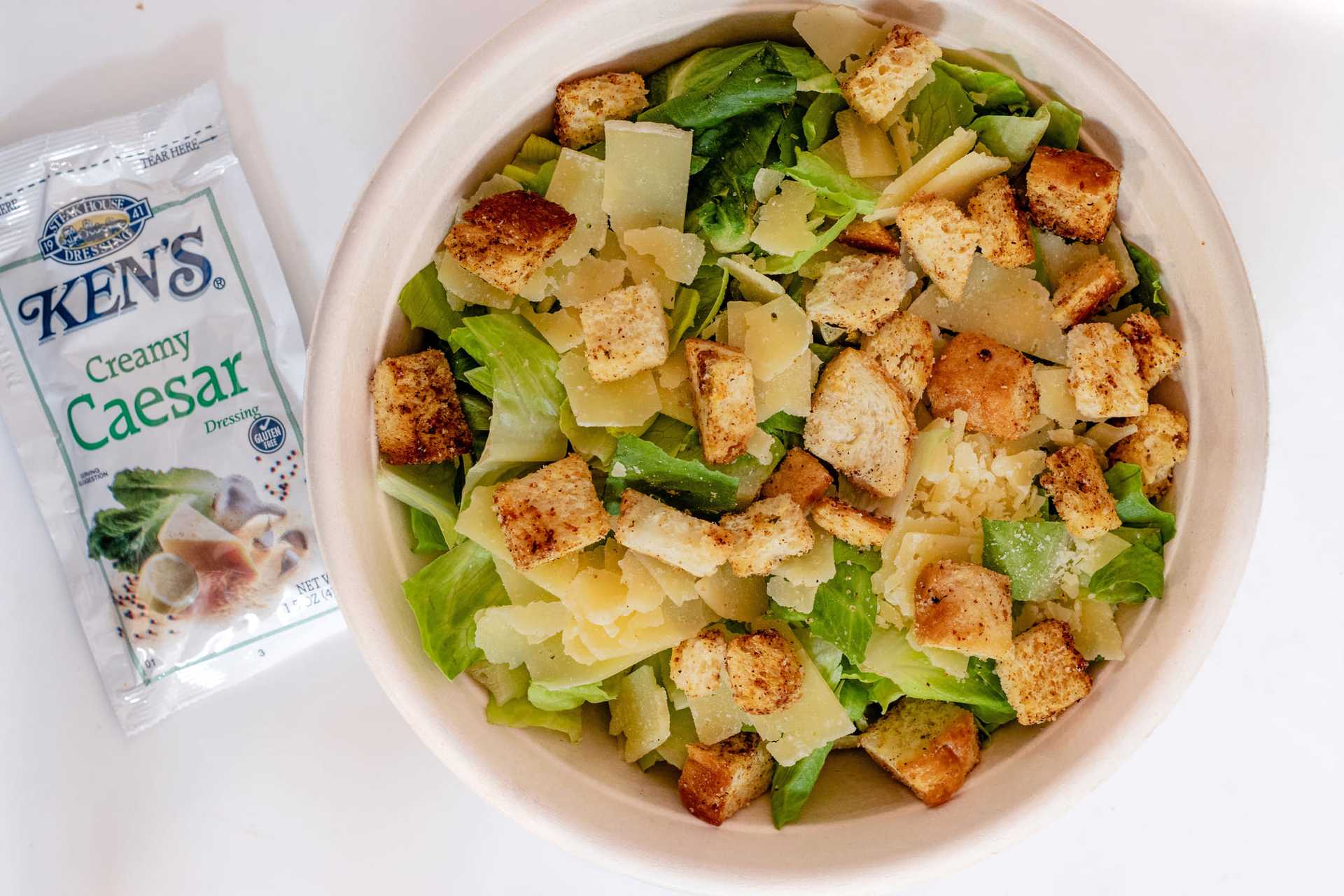 Caesar salad with croutons, lettuce, parmesan, and Ken's Creamy Caesar dressing packet.